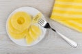 Canned pineapple in saucer, piece of pineapple strung on fork Royalty Free Stock Photo
