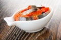 Canned salted herring - imitation salmon in bowl in shape fish on table