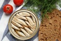 Canned sprats, dill, tomatoes and bread on table, flat lay Royalty Free Stock Photo