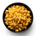 Canned sweet corn in a black ceramic bowl isolated on white. Top view Royalty Free Stock Photo