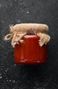 Canned tomato chili sauce in a glass jar.