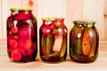 Canned tomatoes and cucumbers in a glass jar on a wooden background Royalty Free Stock Photo