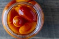 Canned tomatoes in glass jar on wooden rustic table, closeup , home storage solution. Pickled tomato, top view Royalty Free Stock Photo