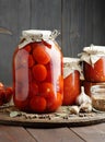 Canned tomatoes in glass jar on wooden rustic table in pantry or village kitchen, closeup Royalty Free Stock Photo