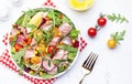 Canned Tuna salad with colorful cherry tomatoes, red onion, sweet corn, paprika, lettuce, radicchio and arugula. White table