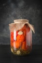 Canned vegetable tomato in glass jars on black wooden board. Homemade harvest and fall preparations