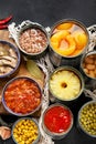 Canned vegetables, beans, fish and fruits in tin cans on black background. Food stocks Royalty Free Stock Photo