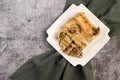 Cannelloni stuffed with meat and cheese baked in bechamel sauce on a square plate on a dark gray background Royalty Free Stock Photo