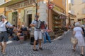 CANNES, FRANCE - August, 2018. Street musician playing on a tourist street, next to a cozy cafe with visitors