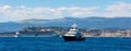 Cannes seafront panorama with Alpes rocky cliffs, port, old town and yacht sailing on waters of Mediterranean Sea in France