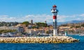 Cannes seafront panorama with lighthouse on breakwater and yacht port at French Riviera of Mediterranean Sea in France