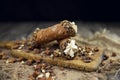 Cannoli, deep fried Italian pastry tubes with a sweet ricotta cheese, chocolate chips and hazelnuts served on a wooden board Royalty Free Stock Photo