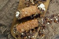 Cannoli, deep fried Italian pastry tubes with a sweet ricotta cheese, chocolate chips and hazelnuts served on a wooden board Royalty Free Stock Photo