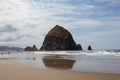 Cannon Beach, Oregon coast: the famous Haystack Rock reflects itself in the water Royalty Free Stock Photo