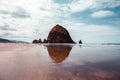 Cannon Beach, Oregon coast: the famous Haystack Rock reflects itself in the water Royalty Free Stock Photo