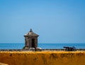 The cannon and guard post of a Spanish-colonial style fort looking out to sea in Mexico