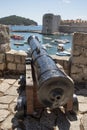 Cannon pointing from the wall at the entrance to the port in Dubrovnik, Croatia