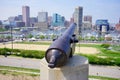 A cannon points to Baltimore downtown skyscraper