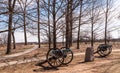 Cannons and a stone monument in a wooded grove with a walkway through it in the Gettysburg National Military Park