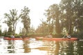 Canoe with active young friends paddling together on a river surrounded by peaceful summer nature on a weekend