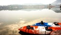 Canoe boats at lake shore in morning. Beautiful reflection of cl Royalty Free Stock Photo