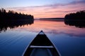 a canoe facing a calm lake at dusk Royalty Free Stock Photo