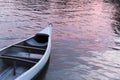 Canoe floating on a stream whose surface glows orange reflecting the sunset Royalty Free Stock Photo