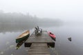 Canoe and kayak tied to a dock on a misty lake - Ontario, Canada Royalty Free Stock Photo