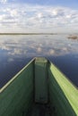 Canoe in a lake with clouds reflected