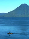 Canoe with lone boatman Lake Atitlan with Toliman volcano, Guatemala Royalty Free Stock Photo