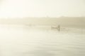 Canoe in the mist on a gloomy day. Healthy lifestyle kayaking in the fog. An enthusiast canoeing on a still, calm Irish sea. Recre Royalty Free Stock Photo