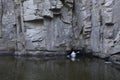 Canoe with people aboard going inside of a cave of rocks. Buksky canyon, Ukraine