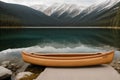 A canoe resting on the edge of a placid lake
