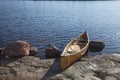 Canoe on rocky shore of northern Minnesota lake at sunset