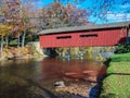 Canoe Trip Passing Underneath Old Covered Bridge On Sunny Autumn Day