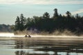 Canoeing at sunrise on a misty lake Royalty Free Stock Photo