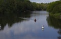 Canoeists approaching buoys on a still river Royalty Free Stock Photo