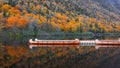 Canoes in a quite lake with fall foliage and reflections.