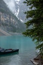 Canoes in turquoise Lake Louise with misty mountains in the background Royalty Free Stock Photo