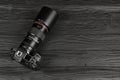 Canon EOS R photocamera and mount adapter EF - EOS R with Canon 105mm f2.8 lens on black wooden table. Photography equipment by