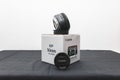 Canon 50mm 1.8 STM Lens on its box on a black table