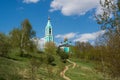 Canonic view of small russian ortodox church over the hill, beautiful summer landscape with trees and a path