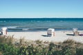 Baltic beach chairs on sand beach against sea Royalty Free Stock Photo