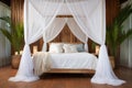 canopy bed with sheer white drapes in a tropical room setting