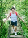 Canopy bridge and man wearing backpacks on footbridge crossing