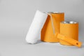 Cans of orange paint and roller brush on grey background. Space for text Royalty Free Stock Photo