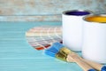 Cans of paint, brushes and color palette samples on blue wooden table. Royalty Free Stock Photo
