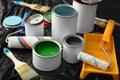 Cans of paint, roller and brush on plastic cover Royalty Free Stock Photo