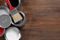 Cans of paints and brush on wooden table, flat lay. Space for text Royalty Free Stock Photo