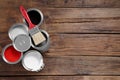 Cans of paints and brush on wooden table, flat lay. Space for text Royalty Free Stock Photo